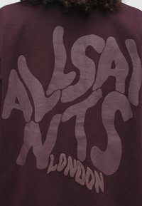 Sweatshirt vinho com design de texto grande e fluido em lilás suave. O texto diz "ALLSAINTS LONDON" com formas irregulares e textura suave.