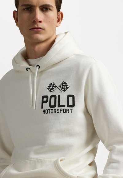 Balsam balts džemperis, izgatavots no mīksta auduma, ar priekšējo kabatu, kapuci ar auklu un melnu "POLO MOTORSPORT" grafikā ar rūtainām karogiem.