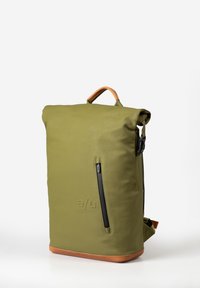 Zaino impermeabile verde a rotolo con tasca frontale con zip, dettagli in pelle marrone e forma rettangolare struttura.