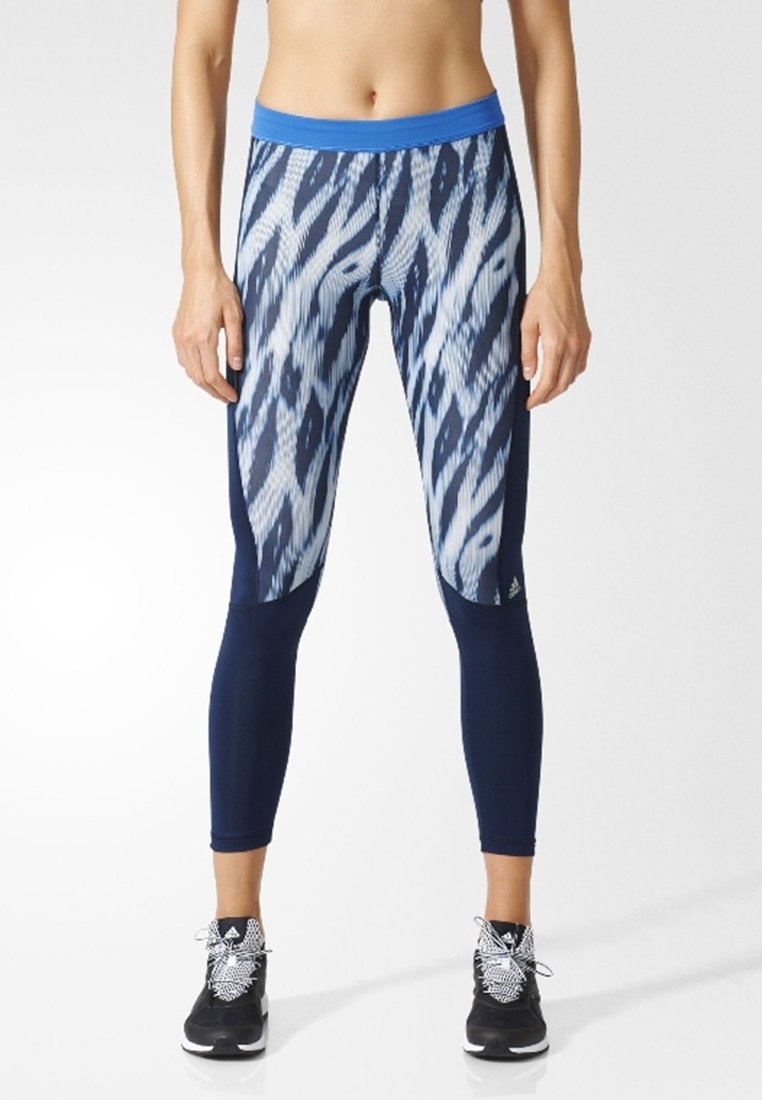 Blaue und marineblaue Leggings mit Muster aus einem dehnbaren Material, ausgestattet mit einem breiten Bund und kontrastierenden einfarbigen Einsätzen an den Seiten.