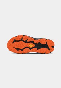 Semelle de chaussure avec une bande de roulement noire et orange vif, présentant un motif rugueux et irrégulier ainsi qu'un logo jaune Vibram près du centre.