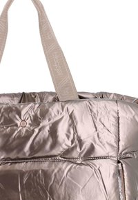 Bolso tote acolchado en taupe brillante con asas de tela anchas, que presenta un sutil texto de marca y un pequeño detalle de logo metálico redondo.