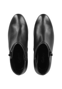 Schwarze Lederstiefeletten mit glatter Oberfläche, runder Zehenpartie und seitlichen Reißverschlüssen. Sie verfügen über eine gepolsterte Innenauskleidung und ein minimales Branding.