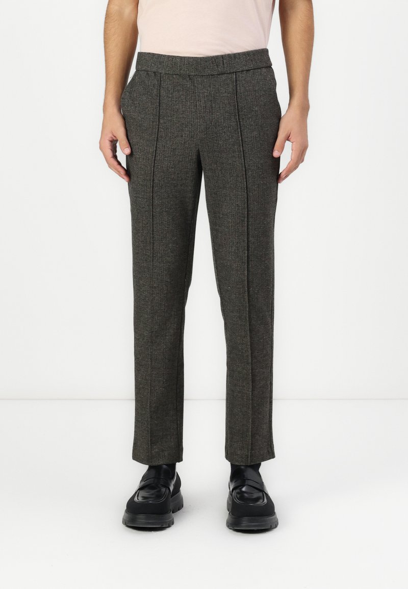 Tailored gray trousers with a subtle pattern, flat front, side pockets, and tapered legs. Made from a textured fabric and worn with black shoes.