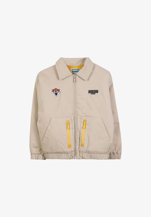 Veste zippée beige avec des poignets élastiques, deux poches zippées jaunes, logo Kenzo Paris sur la poitrine droite et patch de tête de tigre sur la poitrine gauche.