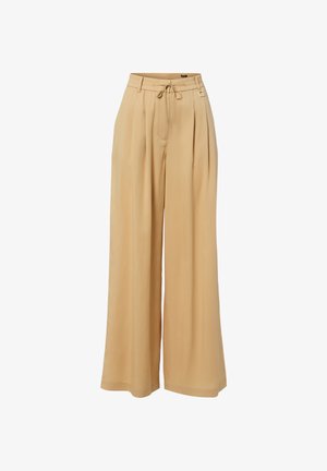 Pantalon beige à jambes larges avec plis, taille ajustable par cordon de serrage et passants de ceinture, en tissu léger.