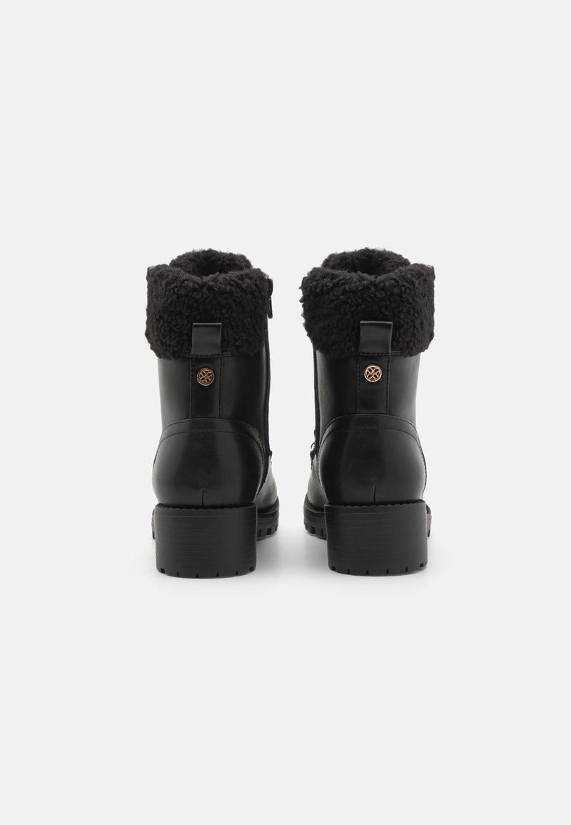 Stivali ankle in pelle nera con un bordo soffice nero, interno testurizzato e tacco basso a blocco. Presentano un accento decorativo sul lato.