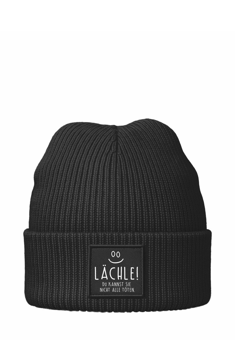 Black ribbed knit beanie with a folded cuff featuring a patch that says "Lächle! Du kannst sie nicht alle töten" and a smiley face.