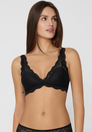 Reggiseno in pizzo nero con coppe triangolari e bordi smerlati. Spalline regolabili e dettagli con motivo floreale creano un aspetto delicato.