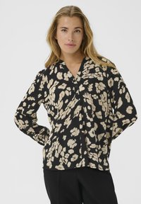 Zwarte blouse met beige bloempatroon, v-hals, lange mouwen en knoopdetails. Lichtgewicht stof, ontspannen pasvorm.