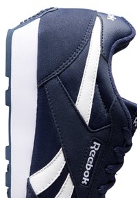 Sneaker blu navy con tomaia in tessuto e accenti bianchi, colletto imbottito, design con lacci e suola in gomma con texture.