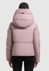 Nafúknutá ružová bunda s kapucňou, ktorá má prešívaný dizajn, elastické manžety a zips na spodnom okraji, zobrazená zozadu na jednoduchom pozadí.