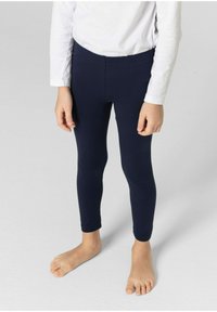Navy stretch leggings made of soft fabric, fitted silhouette, featuring an elastic waistband, paired with a white long-sleeve shirt.