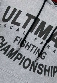 Grijze hoodie met zwarte tekst "ULTIMA LOCAL FIGHTING CHAMPIONSHIP," voorzien van een trekkoord en zachte, gestructureerde stof.