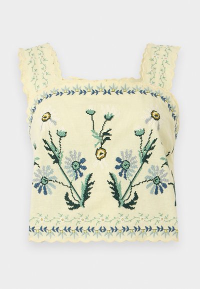 Κίτρινο κοντό τοπ με μπλε και πράσινα λουλουδάτα κεντήματα και κυματιστές άκρες στα λουράκια και το τελείωμα.