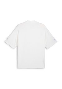 T-shirt en coton blanc à manches courtes, col rond classique, avec un logo imprimé sur la manche gauche. Texture lisse et design simple.