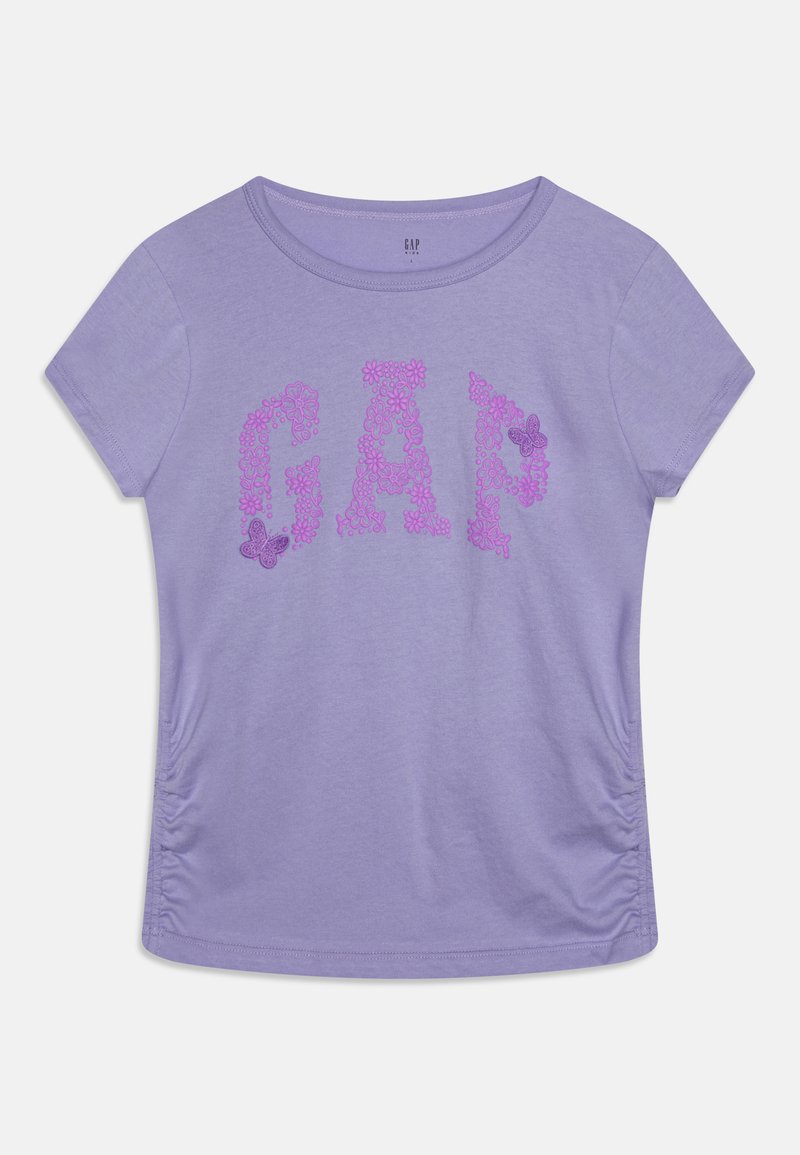 Lilla lühikeste varrukatega T-särk, millel on sõna "GAP" roosa lillemustriga, volangidega külgedel ja ümar kaelus.