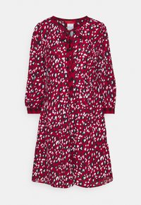 Punainen mekko, jossa on leopardikuosiset mustat, valkoiset ja vaaleansiniset yksityiskohdat. Mekossa on pitkät hihat ja nappikiinnitys, jossa on kaulus.