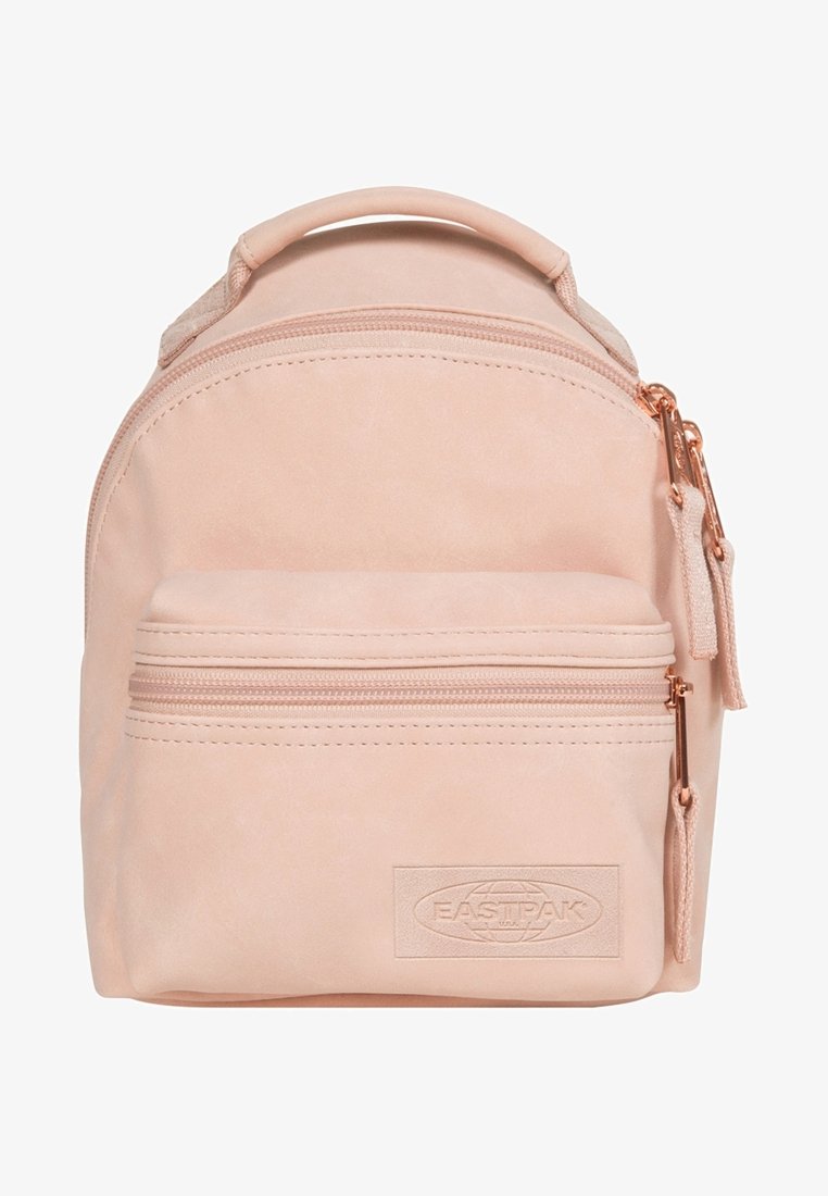 Light pink backpack with a rounded shape, smooth leather-like texture, front zipped pocket, and rose gold hardware accents.