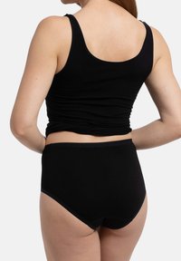 Canotta nera in cotone e mutande a vita alta, con una texture liscia e un design semplice, senza motivi visibili o accessori.