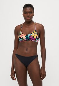 Bikini top s květinovým vzorem v živých barvách s tenkými ramínky, doplněný jednobarevnými černými spodními díly; hladká textura, střední krytí.