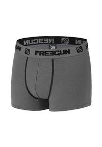 Boxers gris avec une taille élastique noire comportant le logo "FREEGUN", en tissu doux et avec une coupe ajustée. Coutures plates pour le confort.