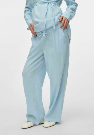 Ensemble de maternité bleu clair composé d'un haut ample à manches longues avec un nœud et d'un pantalon large à taille élastique assorti. Texture de tissu lisse.