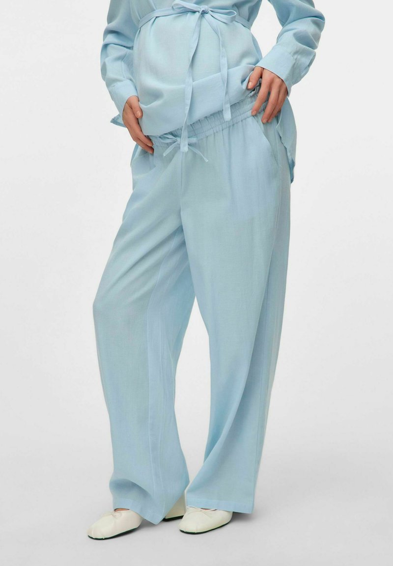 Conjunto de maternidad azul claro que incluye una blusa de manga larga y holgada con lazo y pantalones anchos de pierna recta con cintura elástica a juego. Textura de tela suave.
