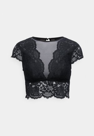 Must pitsikate varrukatega pitsist lõikepusa, millel on lillemuster, läbipaistev kangas ja laineline serv. Tagaküljel väike kinnis.