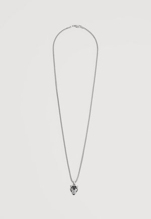 Collar de cadena plateada con un colgante detallado en forma de cabeza de lobo sobre un fondo claro y liso.