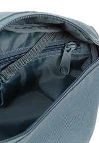 Sacca in tessuto blu con apertura con cerniera, caratterizzata da una superficie testurizzata, forma rettangolare e una piccola tasca interna.