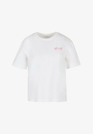 Valge puuvillane t-särk lühikeste varrukatega, millel on vasakul rinnal kolm väikest roosa südame graafikat. Klassikaline ümmargune kaelus.