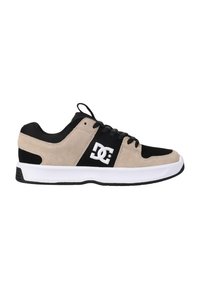 Beige ja must spordijalanõud, mis on valmistatud nahast ja võrgust, valge tallaga, nööbikinnitusega ja külgedel logo.