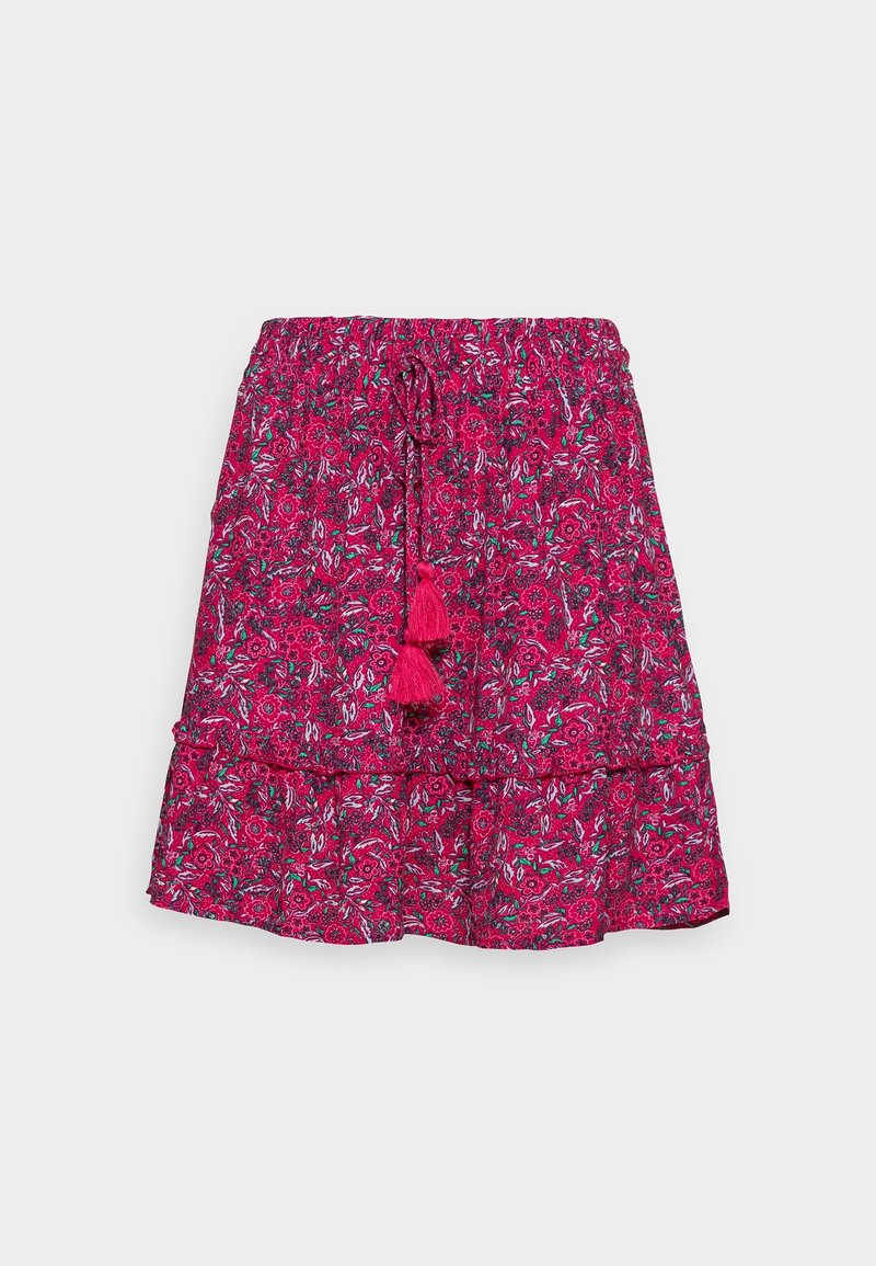 Jupe fleurie rose vif avec taille élastique et cordon avec deux pompons, ourlet volanté superposé sur fond uni.