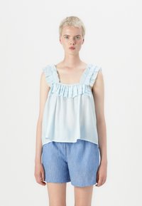 Lichtblauwe blouse met ruches en een gathered halslijn, met brede bandjes, gecombineerd met blauw-wit gestreepte shorts. Zachte stof, losse pasvorm.