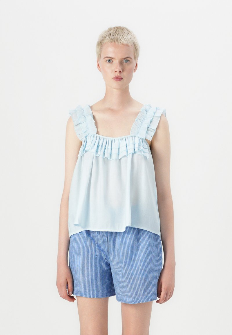 Lichtblauwe blouse met ruches en een gathered halslijn, met brede bandjes, gecombineerd met blauw-wit gestreepte shorts. Zachte stof, losse pasvorm.