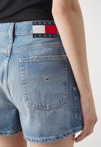 Jeansshorts i ljus tvätt med fransad fåll. Har en Tommy Jeans-logotyp på bakre midjan och två bakfickor med sömmar.