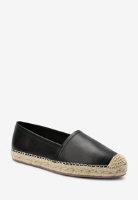 Schwarze Leder-Espadrille mit einer Sohle aus gewebtem Jute, ausgestattet mit einer abgerundeten Spitze, einem gewebten hellbeigen Akzent und kontrastierenden schwarzen Nähten.