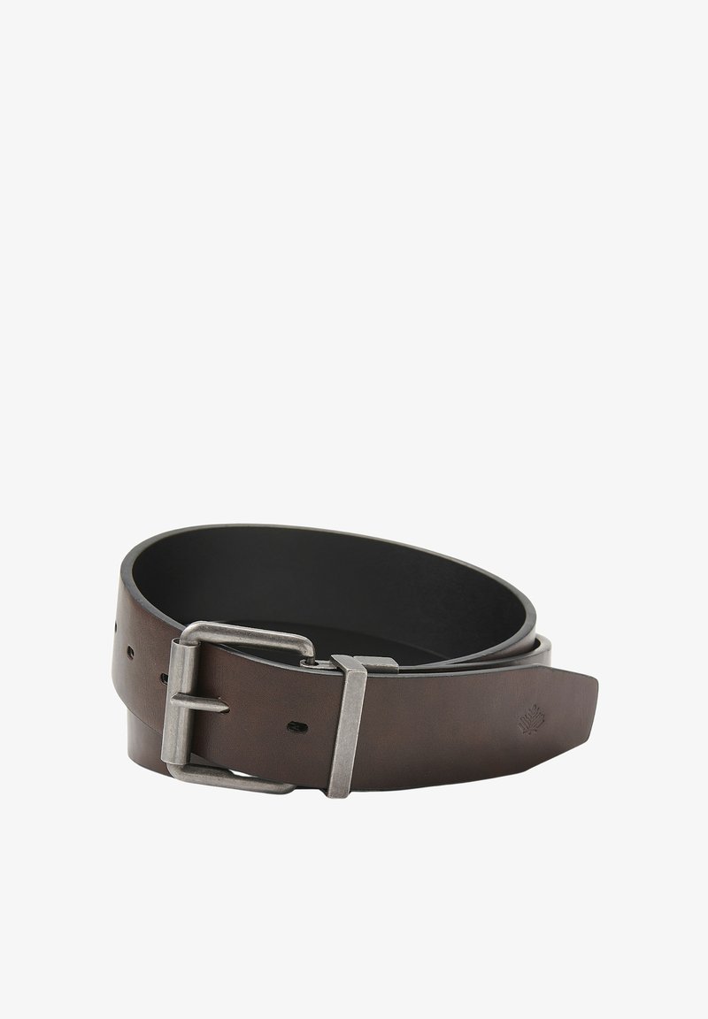 Bruine leren riem met een matte zilveren gesp, met een gladde textuur en gaatjes voor verstelbaarheid. Het ontwerp is klassiek en functioneel.