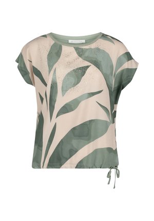 Beżowa bluzka z krótkim rękawem, z zielonym abstrakcyjnym nadrukiem liści oraz regulowanym sznurkiem u dołu.