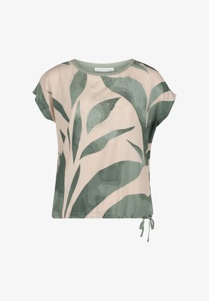 Blouse beige à manches courtes avec imprimé abstrait de feuilles vertes et ourlet à cordon de serrage ajustable.