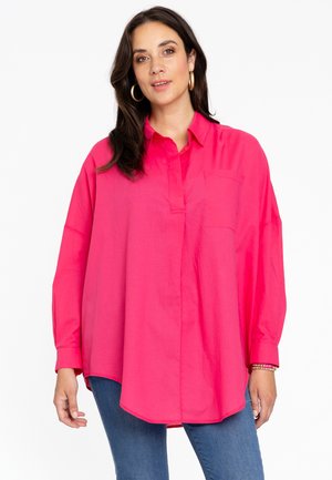 Chemise à manches longues rose vif avec un col boutonné, poche avant et coupe décontractée. Fabriquée en tissu léger et lisse.