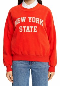 Sweat-shirt en polaire rouge avec « NEW YORK STATE » imprimé en crème. Comprend des poignets et un ourlet côtelés, une coupe décontractée et une texture douce.