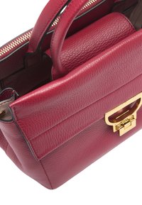 Sac à main en cuir rouge texturé avec des poignées courtes à double, quincaillerie dorée et fermeture éclair. Présente un design structuré et de subtils détails de couture.