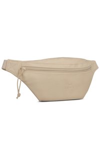 Beige bőr deréktáska sima felülettel, megnyúlt formával, felső cipzárral záródik, az elején dombornyomott logó részlettel.