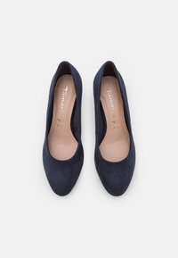 Paire d'escarpins pour femmes en daim bleu marine à bout rond avec semelles intérieures beige, vus de dessus sur un fond clair.