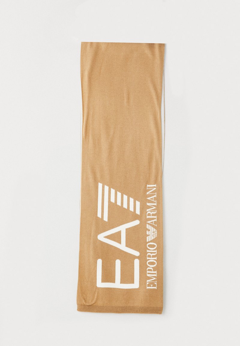 Leggings color sabbia realizzati in un materiale morbido, con un design elegante. Sul lato è presente il logo in rilievo "EA7 Emporio Armani" in bianco.