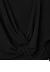 Top in cotone nero con dettaglio annodato sull'orlo, realizzato in tessuto drappeggiato che crea morbide pieghe. Texture liscia e silhouette rilassata.