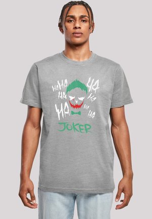 Grå bomull T-skjorte med Joker-grafikk, grønt hår, rød og hvit ansiktsfarge, og "JOKER" tekst i grønt. Korte ermer, rund hals.
