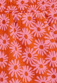 Bombažna tkanina z teksturiranim tkanjem, z živahno oranžno ozadjem in velikimi rožnatimi cvetličnimi vzorci.